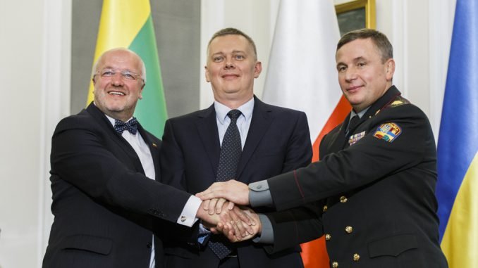 Ukrainian Defense Minister Valeriy Heletey (R), Polish Defense Minister Tomasz Siemoniak (C) and Lithuanian Defense Minister Juozas Olekas shake hands after signing an agreement on the creation of a joint military brigade on Sept. 19 in Warsaw.