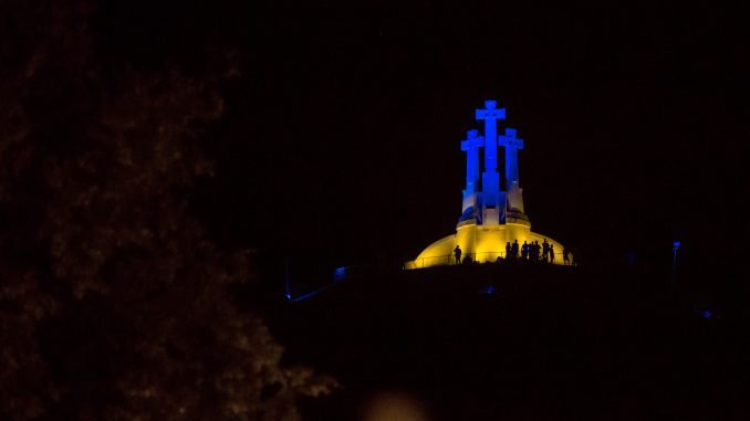Three Crosses Hill lit with the colours of the Ukrainian flag